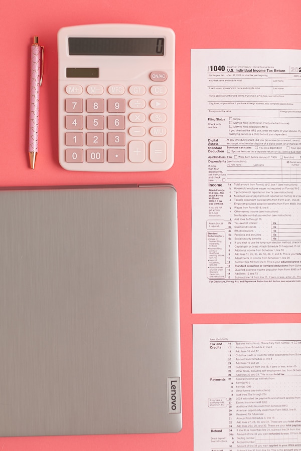 individual income tax return with a computer and calculator on a pink background